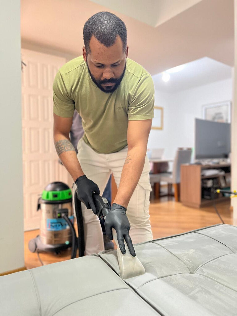 Aluno higienizando sofá com extratora